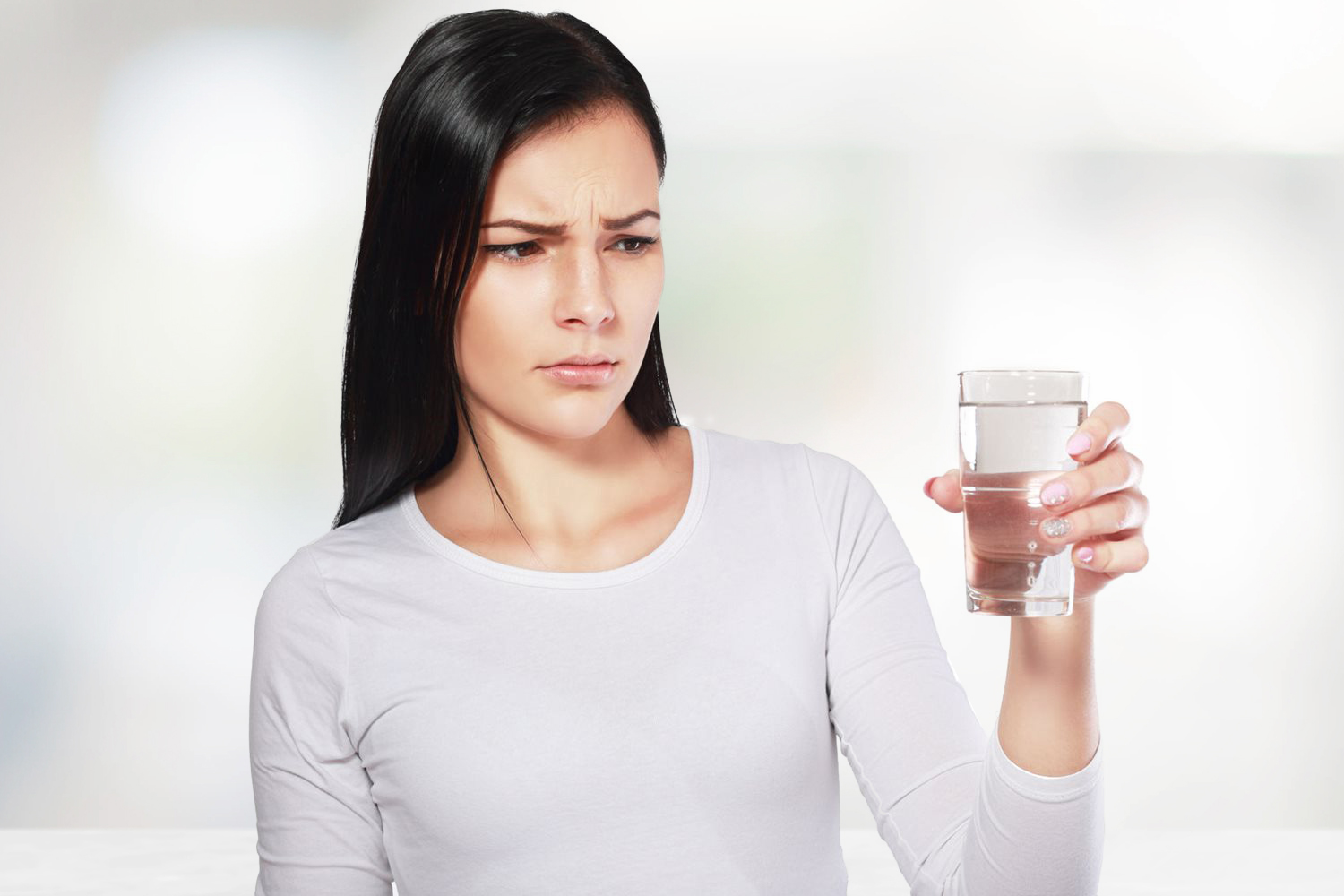 An annoyed person holding a foggy glass filled with water.