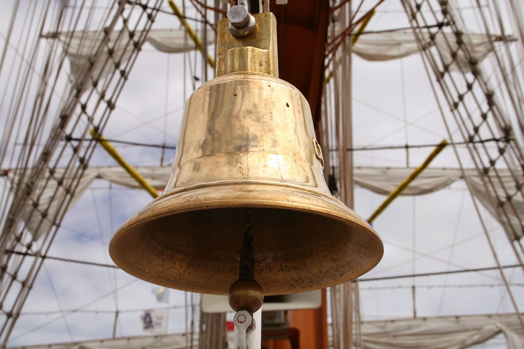 A tarnished bell swinging on a ship.